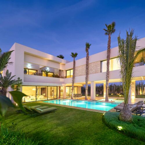 Villa Moorea à Marrakech : façade illuminée et piscine au crépuscule