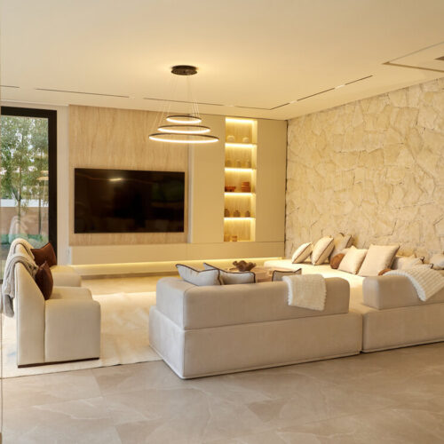 Salon avec mur en pierre et banquettes